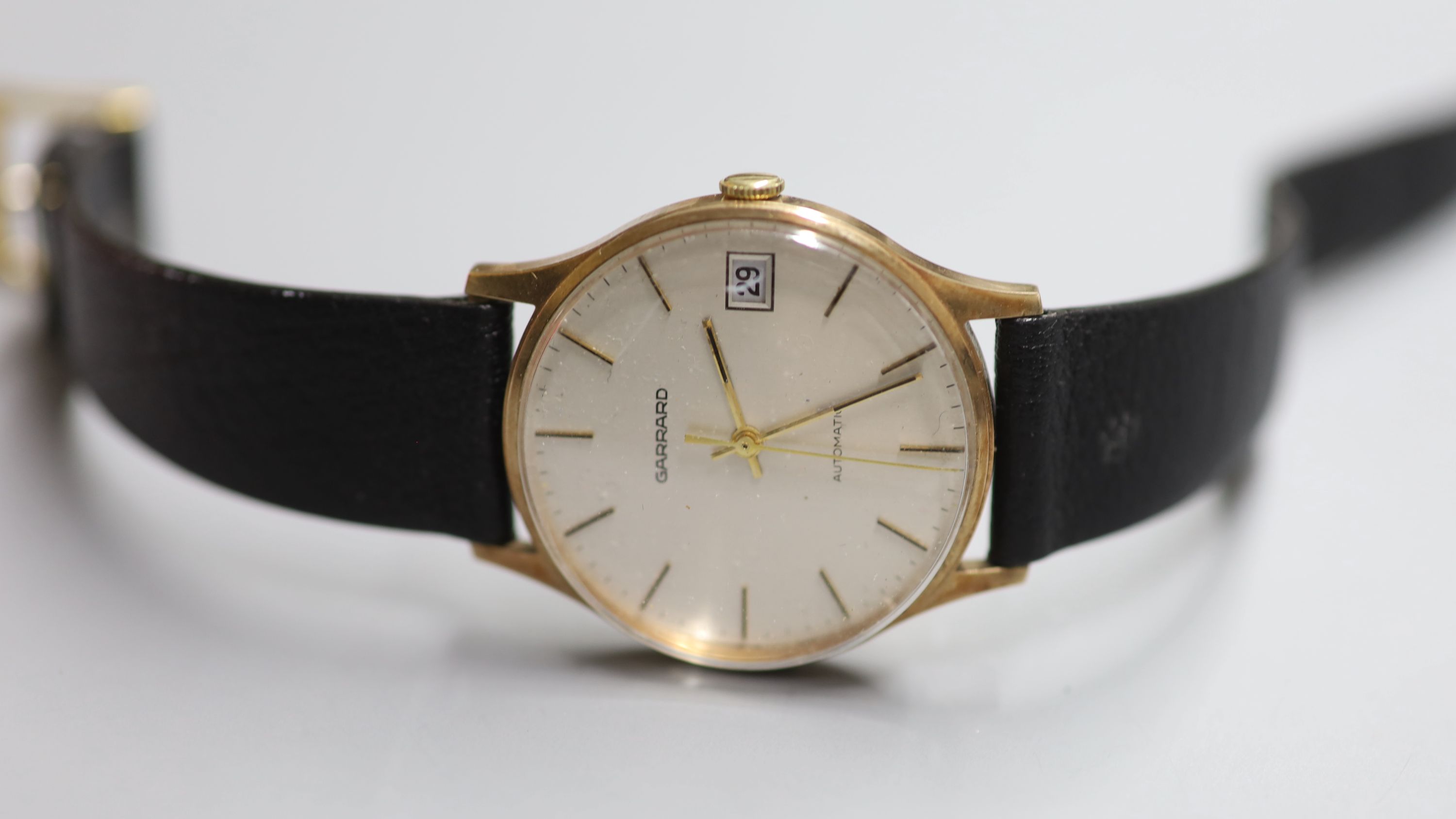 A gentlemans 1980s yellow metal automatic wrist watch, retailed by Garrard, with case back inscription,